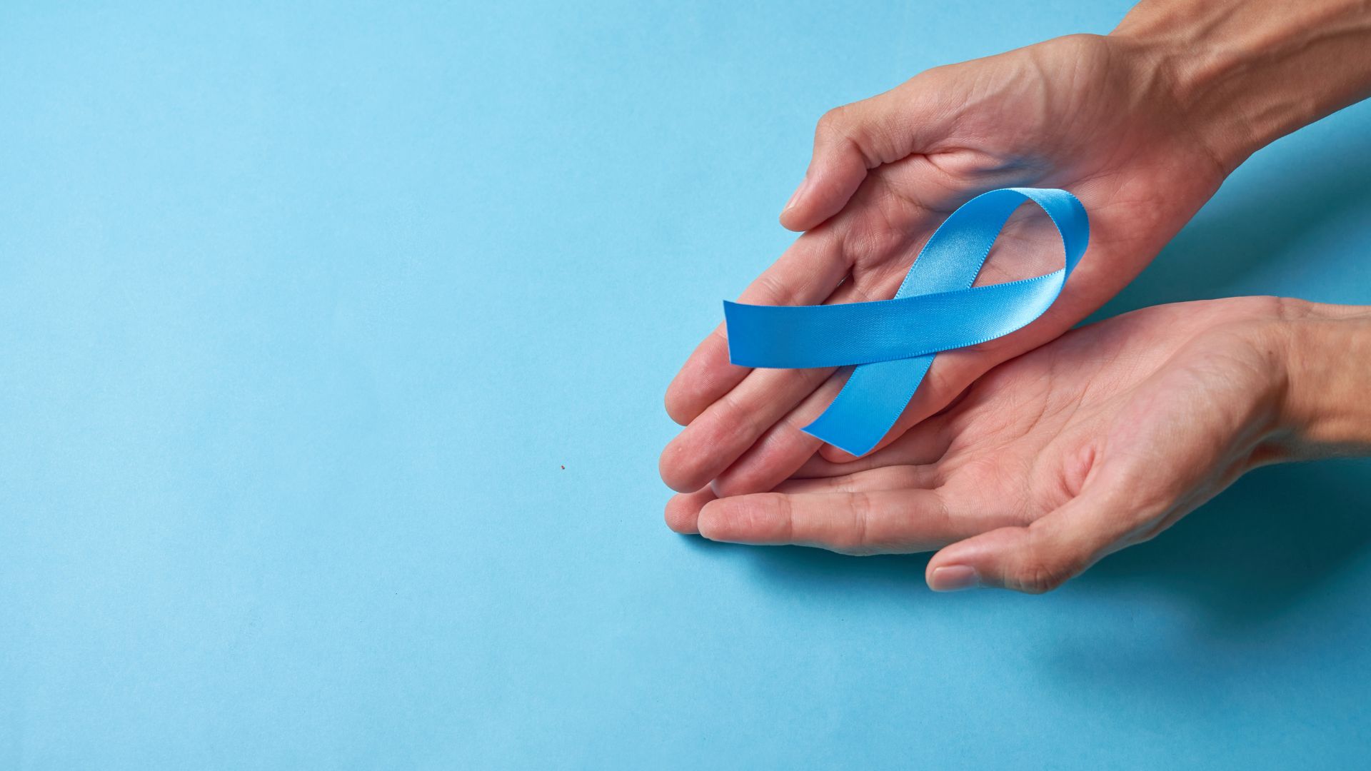 Prostatakrebs, blaue Schleife in Hand